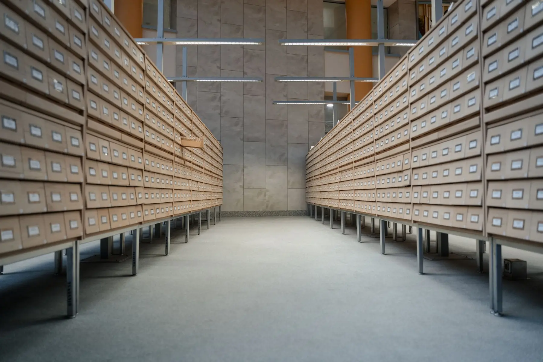 A long archive room lined with wooden filing drawers